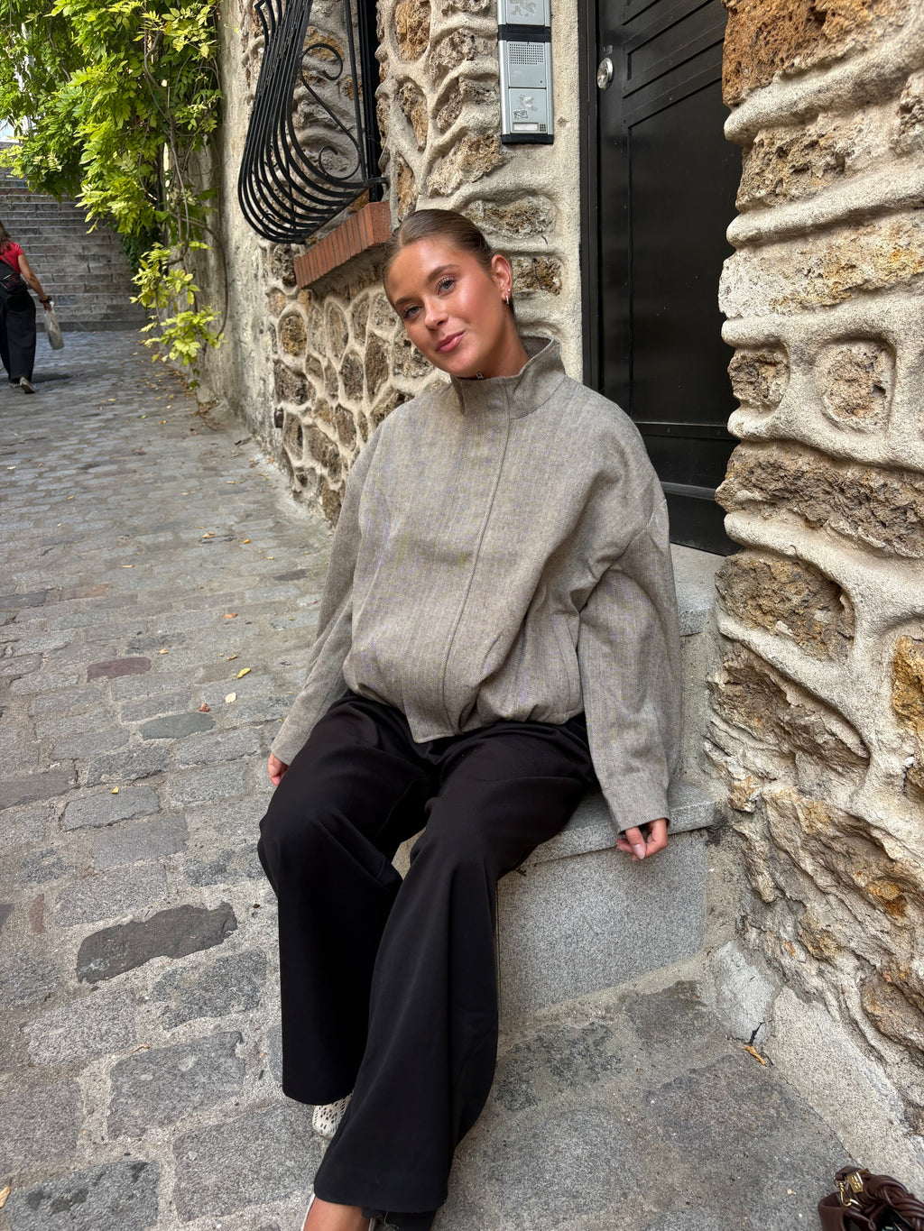 Beige damesjas met fijne streepjes, opstaande kraag en knoopsluiting, gecombineerd met een zwarte pantalon. Trendy jacket en elegant outerwear, beige Damenjacke en gemusterte Übergangsjacke van ByLies.
