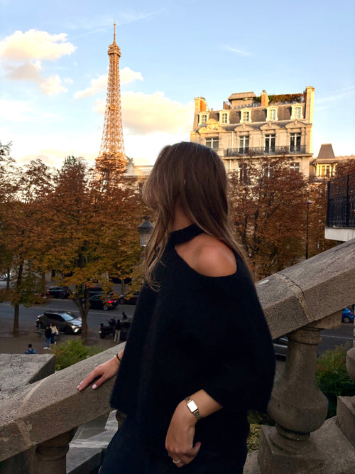 Elara zwart – zachte fluffy gebreide damestrui met asymmetrische one-shoulder hals en oversized pasvorm van By Lies.